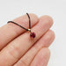 14kt yellow gold lab-grown ruby pendant shown on fingertips for scale