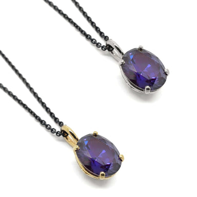 Two oval lab grown purple sapphire pendants in yellow and white 14kt gold on black chains