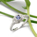 Lavender sapphire and lab diamond 14kt white gold ring with vintage-inspired millgrain, on white background with greenery