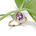 Lavender sapphire and lab diamond engagement ring in yellow gold, displayed with green leaves