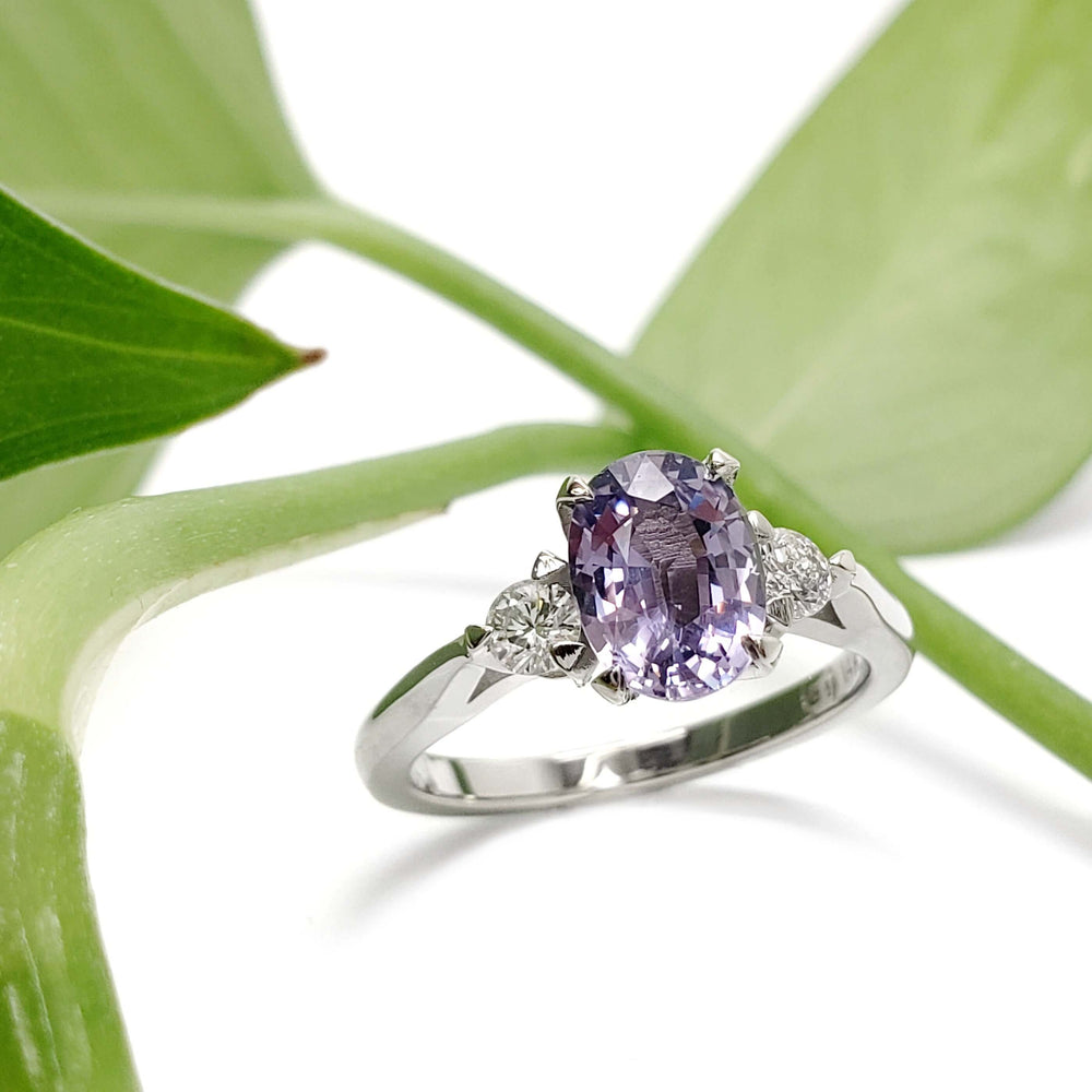 Lavender sapphire and lab diamond ring in white gold, displayed on a green leaf