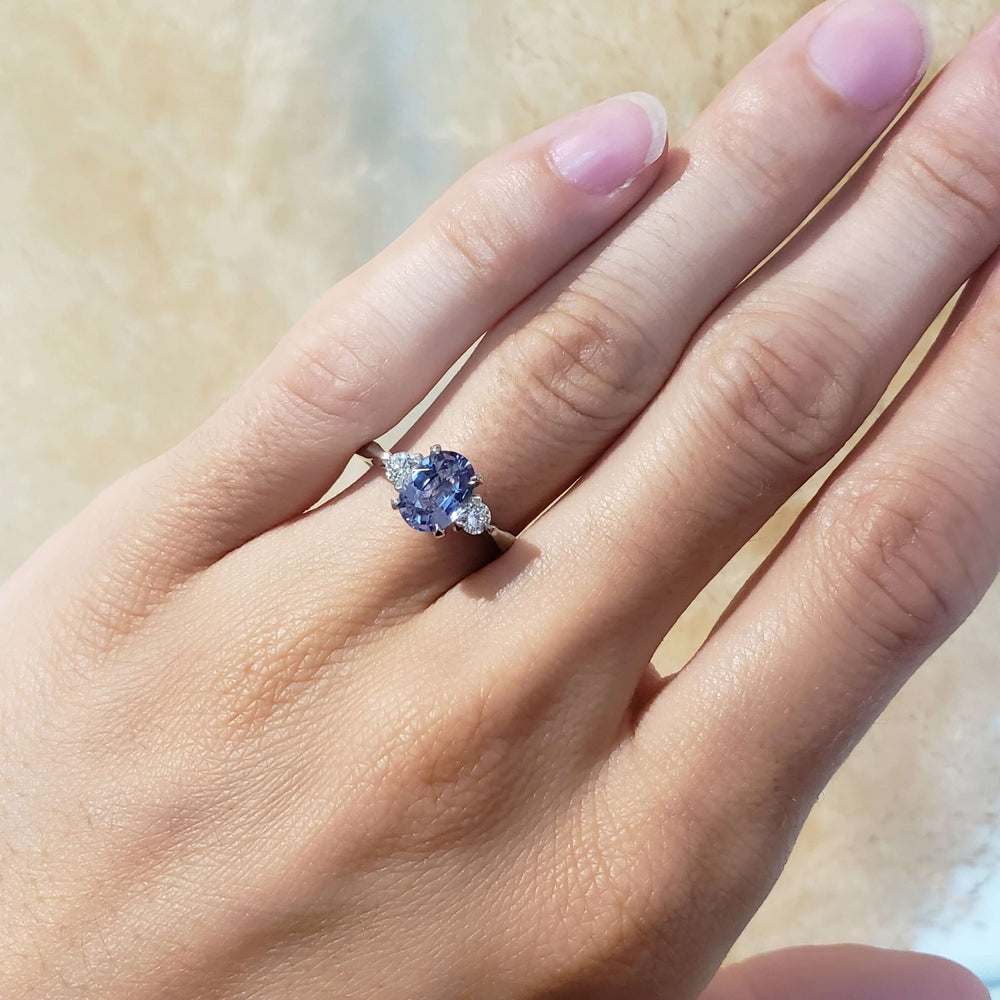 Lavender sapphire and lab diamond white gold ring worn on a hand