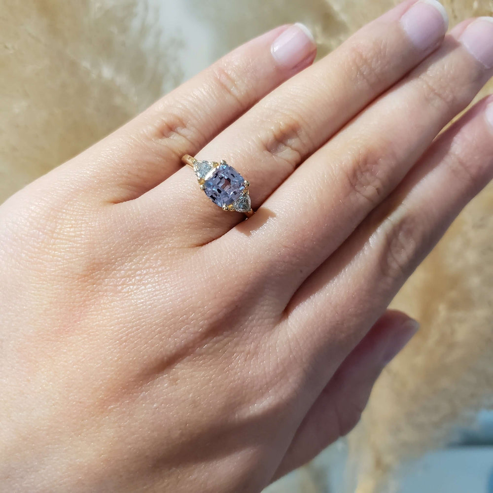 Lavender sapphire and lab diamond yellow gold ring worn on hand