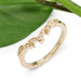 Leaf-inspired yellow gold diamond wedding ring beside a green leaf
