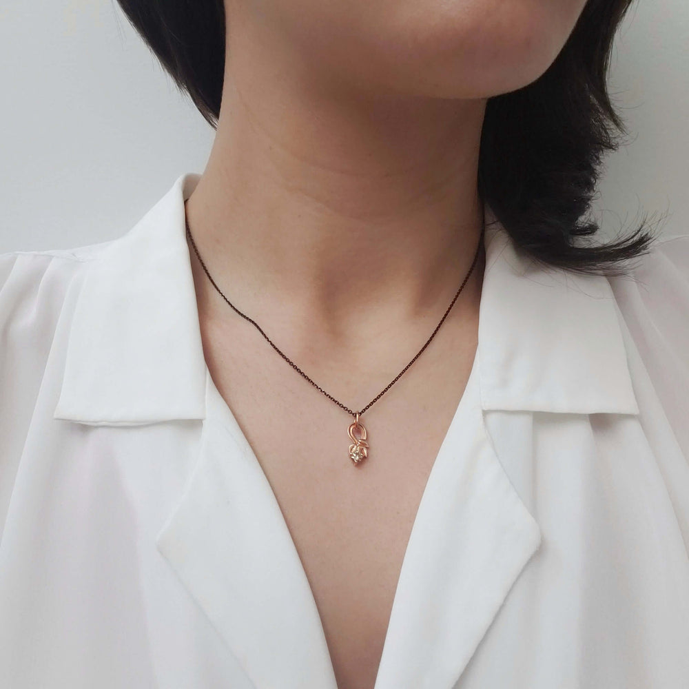 Leafy champagne diamond pendant in rose gold worn on a black chain