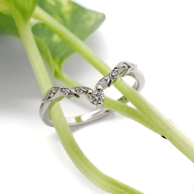 Leafy diamond wedding ring in 14k white gold displayed on green plant stems