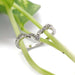 Leafy diamond wedding ring in 14k white gold displayed on green plant stems