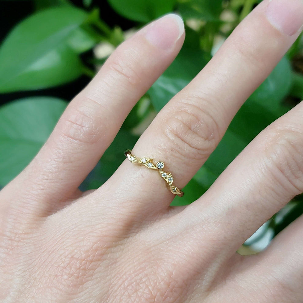 Leafy diamond wedding ring in yellow gold worn on a hand