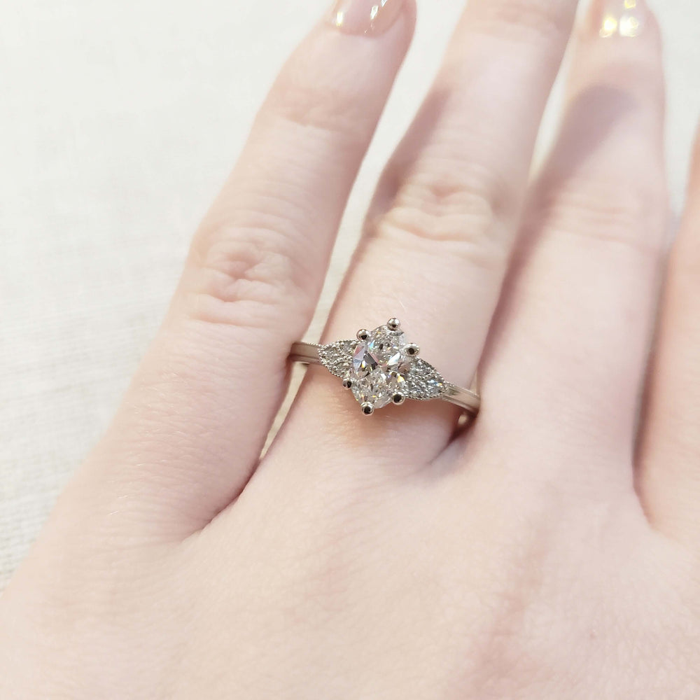 Lucia engagement ring with oval lab diamond and millgrain, shown on hand