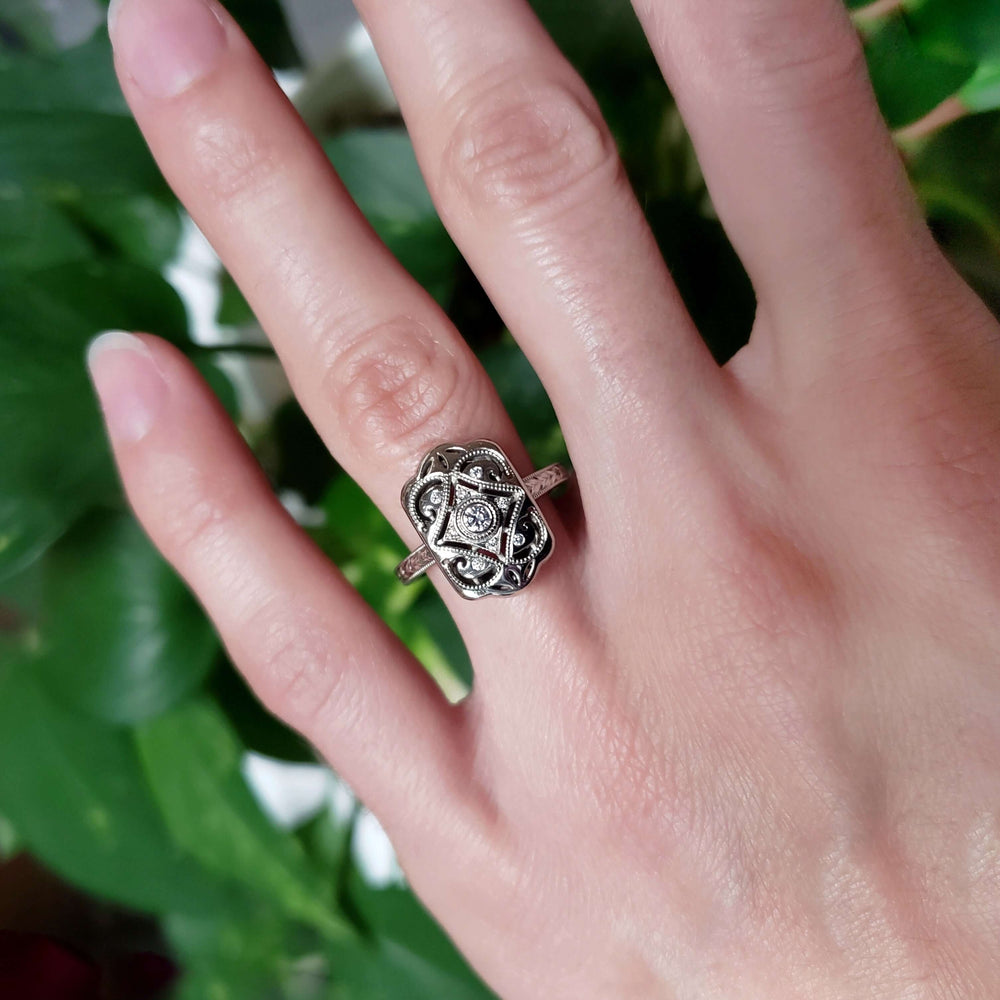 Majesty 14kt white gold diamond engagement ring shown on hand against green foliage