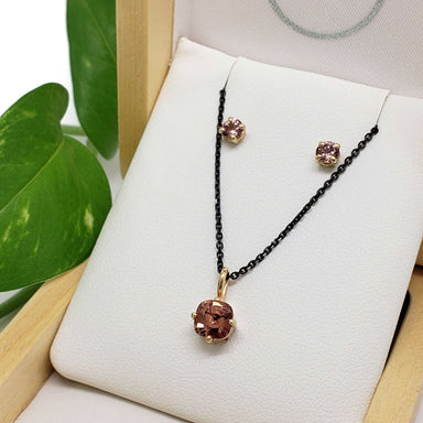 Malaya garnet pendant and stud earrings in 14kt yellow gold displayed in a box