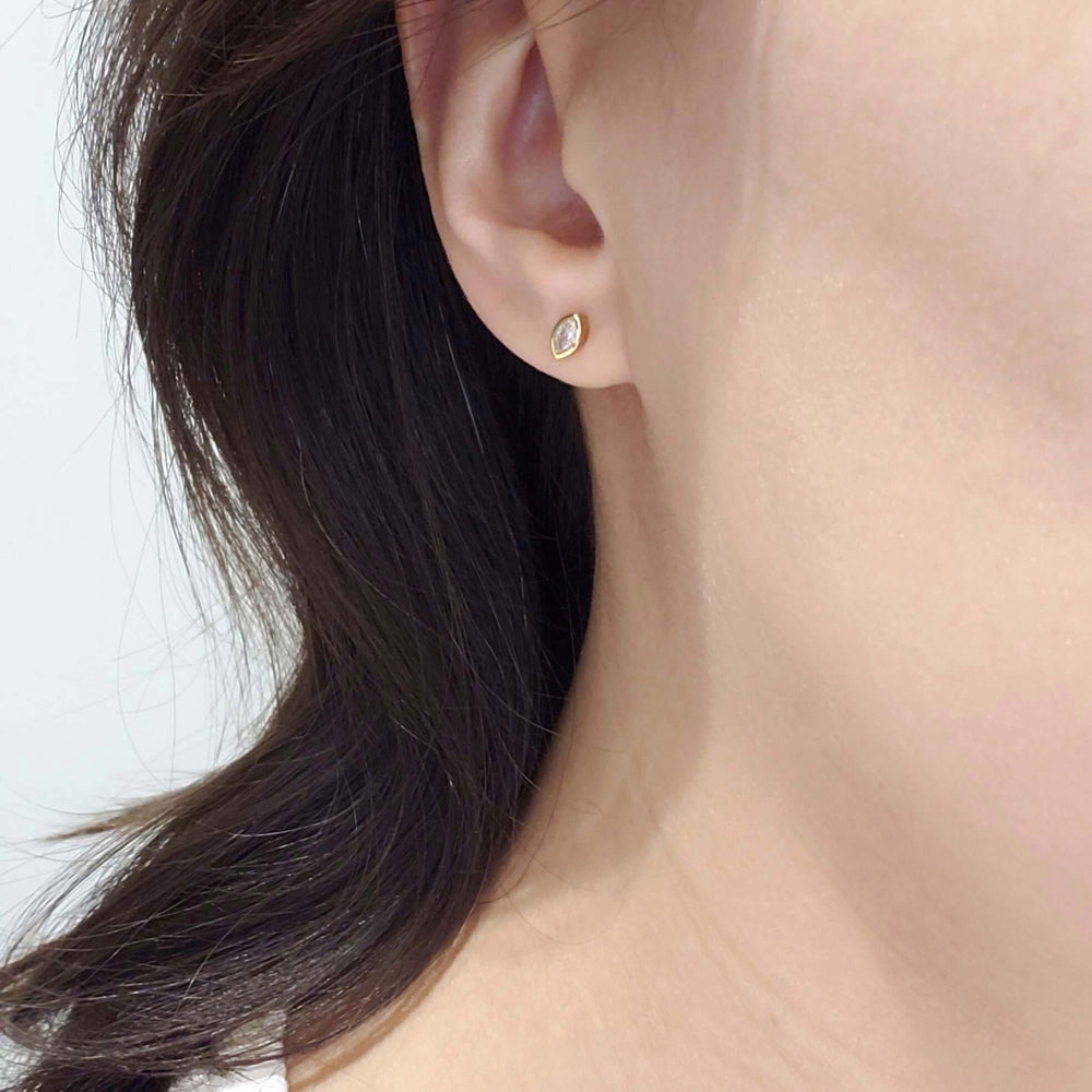 Marquise diamond bezel stud earring in 14kt yellow gold worn on ear