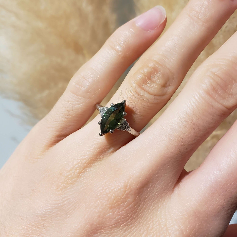 Marquise green sapphire and diamond ring in white gold shown on hand
