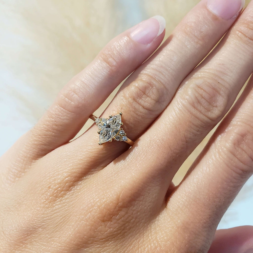 Marquise lab diamond engagement ring in yellow gold shown on hand