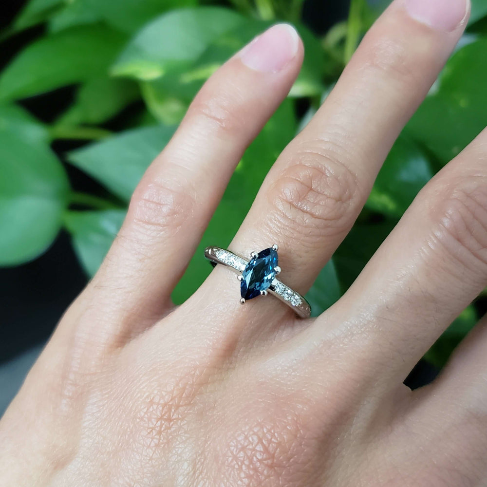 Marquise teal Australian sapphire and diamond ring in white gold, shown on hand