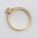Side view of a yellow gold ring with millgrain edge and raised diamond setting