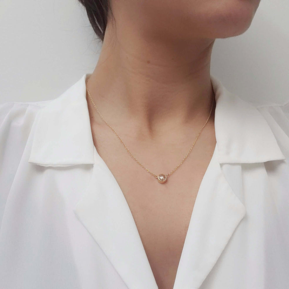 Model wearing 14kt yellow gold necklace with bezel-set rose cut moissanite