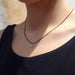 14kt yellow gold and blue zircon pendant necklace on model, black chain