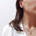 Model wearing London blue topaz stud earrings and pendant necklace in 14kt yellow gold