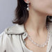 Model wearing faceted clear quartz bead necklace with matching earrings