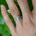 Moissanite and diamond white gold engagement ring shown on hand