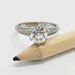 Moissanite and diamond engagement ring in white gold, shown next to a pencil for scale