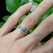 Moissanite and lab diamond engagement ring with matching band on hand