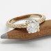 Close-up of moissanite solitaire ring in 14k yellow gold with engraved band