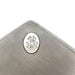 Close-up of monogrammed silver medallion on textured cigar box lid