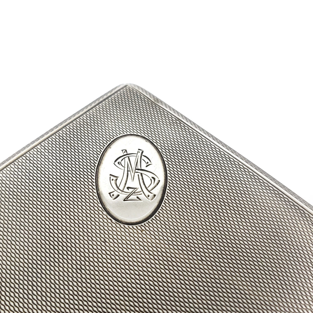 Close-up of monogrammed silver medallion on textured cigar box lid