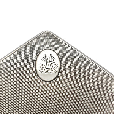 Close-up of monogrammed silver medallion on textured cigar box lid