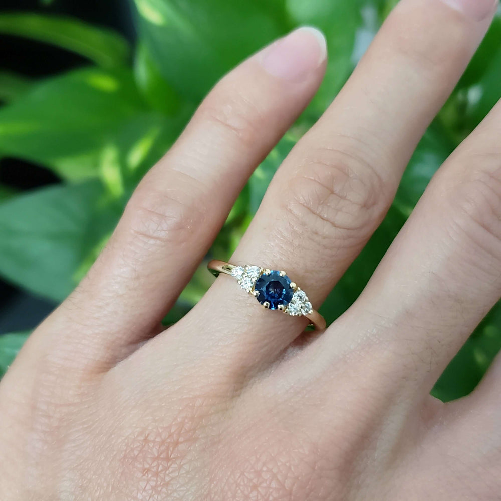 14k yellow gold Montana sapphire and diamond ring worn on a hand