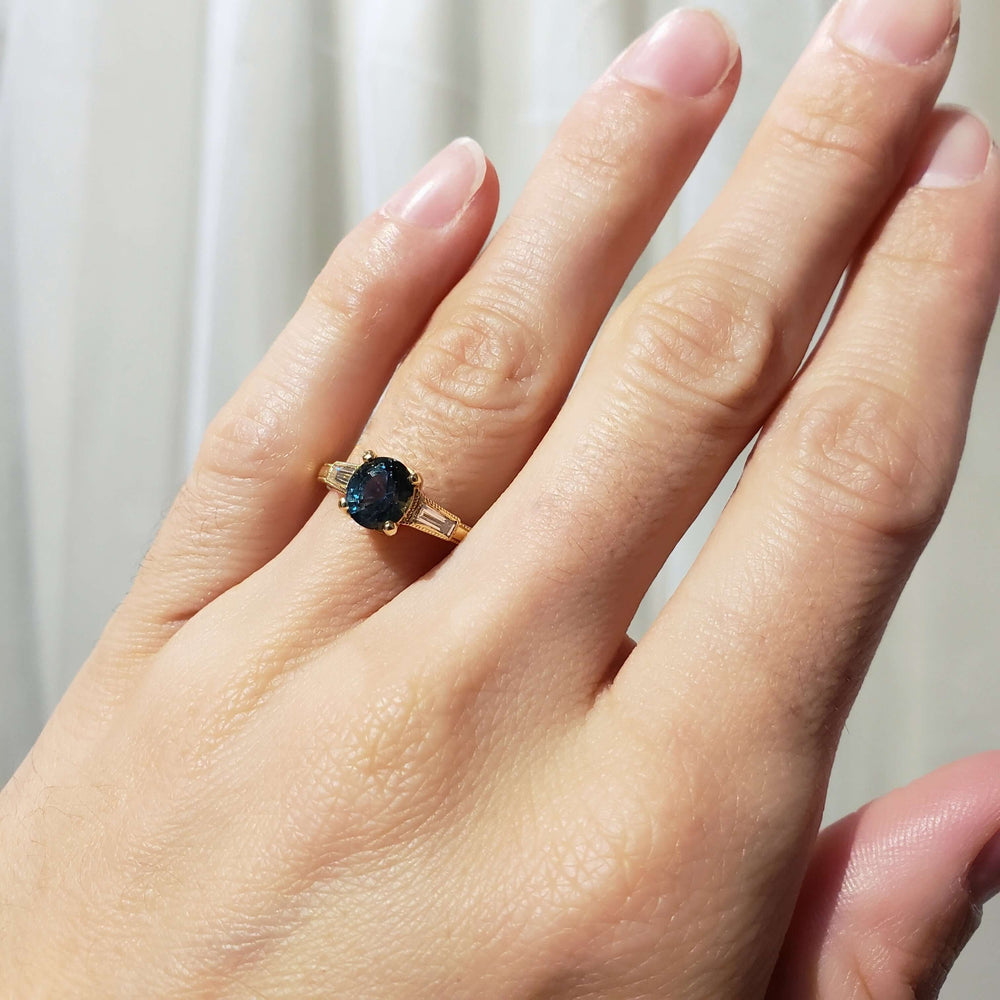 14K yellow gold Montana sapphire and diamond ring worn on a hand