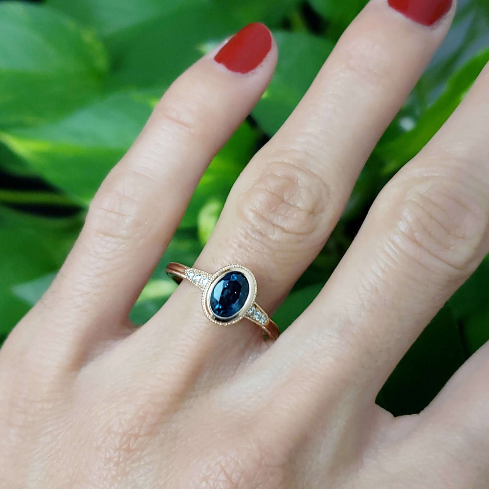 14kt rose gold Montana sapphire and diamond ring worn on a hand