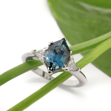 Montana sapphire and diamond engagement ring in white gold, displayed on green leaves