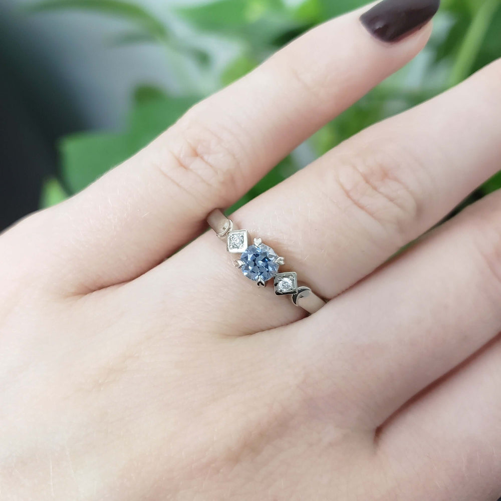 Montana sapphire and diamond engagement ring in white gold, shown on a hand