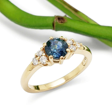 14k yellow gold Montana sapphire and diamond ring, top view with green stem background
