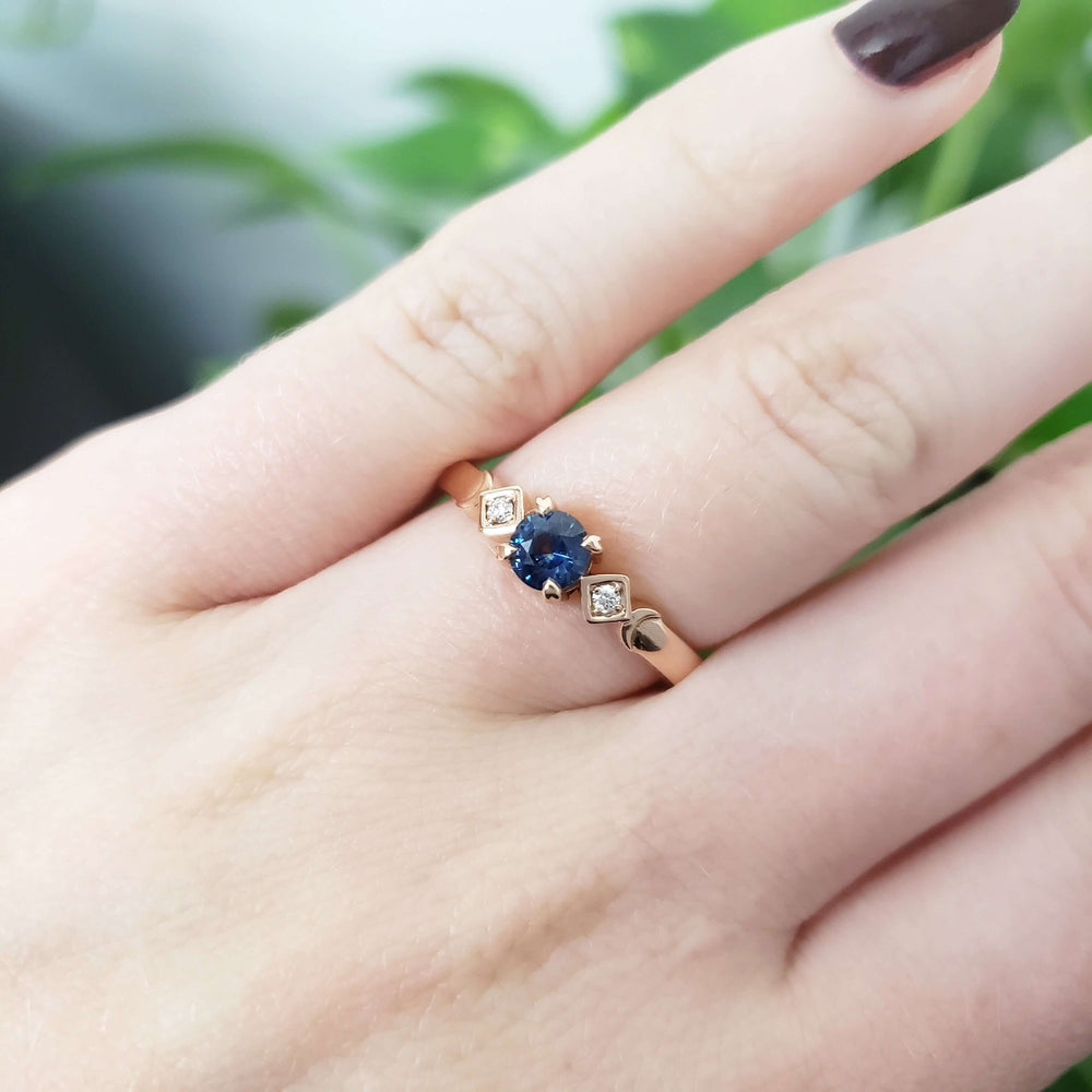 14kt rose gold Montana sapphire and diamond ring worn on a hand