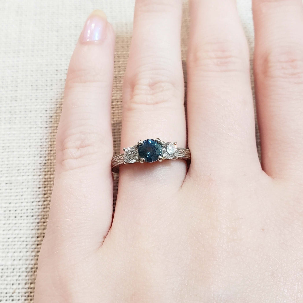 Montana sapphire and diamond three-stone ring in white gold, shown on hand