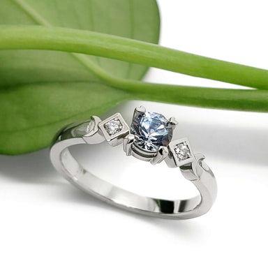 Montana sapphire and diamond engagement ring in white gold, styled with a green leaf