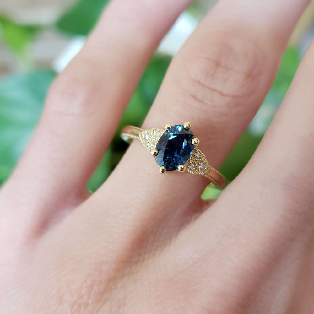 Montana sapphire and diamond yellow gold engagement ring on hand
