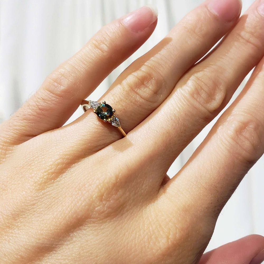 Montana sapphire and lab diamond engagement ring in yellow gold shown on hand