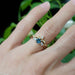 Montana sapphire and lab diamond ring stacked with a yellow gold diamond band on a hand