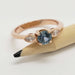 14kt rose gold Montana sapphire and marquise diamond ring displayed on a pencil