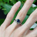 Montana sapphire engagement ring in white gold, stacked with leaf motif band on hand