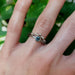 Montana sapphire engagement ring stacked with diamond band, both in white gold, on hand