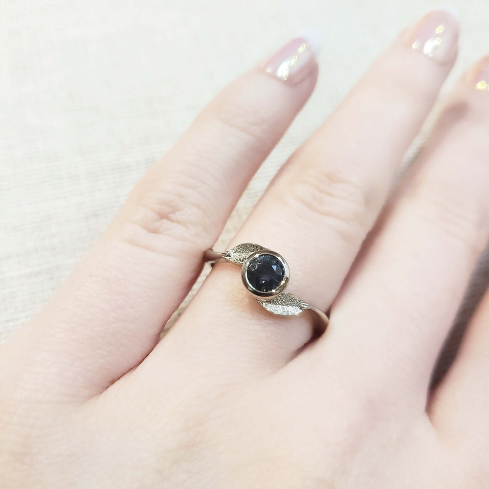 14kt white gold Montana sapphire leaf ring worn on a hand