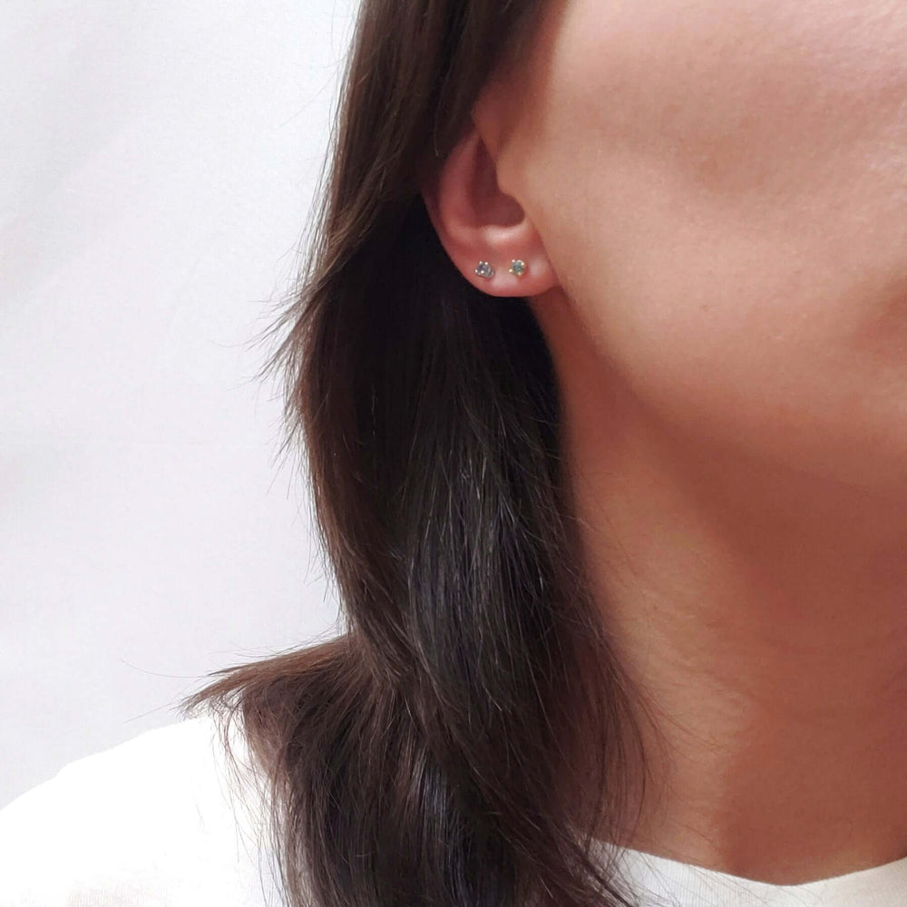 Montana sapphire stud earrings in yellow and white gold worn on ear