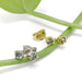 Montana sapphire stud earrings in yellow and white 14kt gold displayed on a green stem