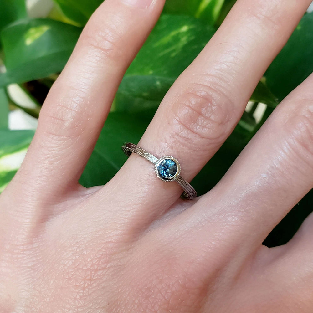 Montana sapphire white gold engagement ring on hand, intricate engraved details